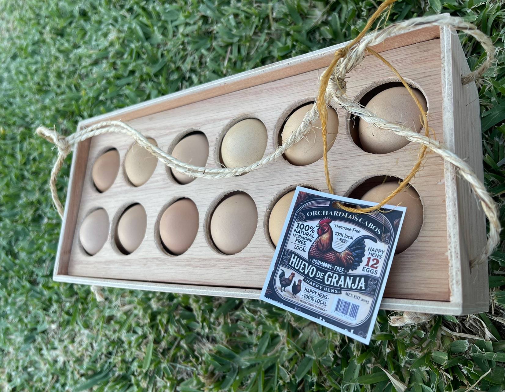 A wooden Orchard egg crate tied with twine and tagged with the farm's label.